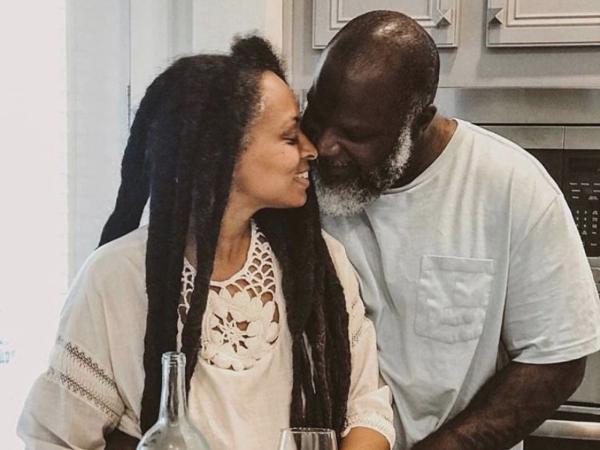 A middle-aged couple share a quiet moment together in their kitchen