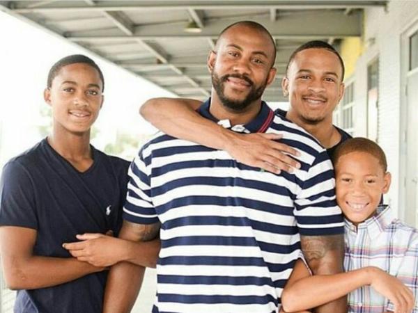 A father stands embraced by his four sons