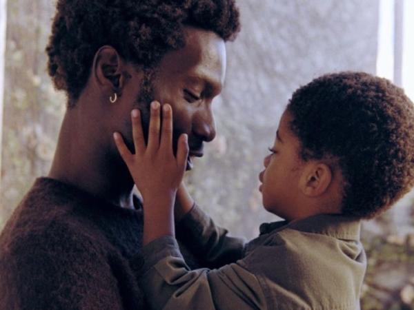 A father holds his toddler close, foreheads touching