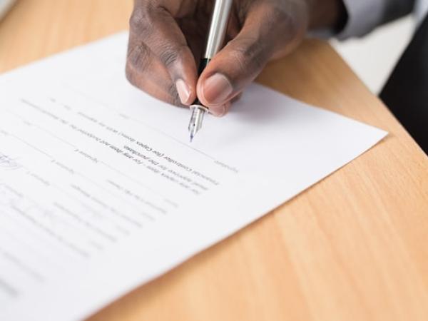 A person signing a document with a fountain pen.