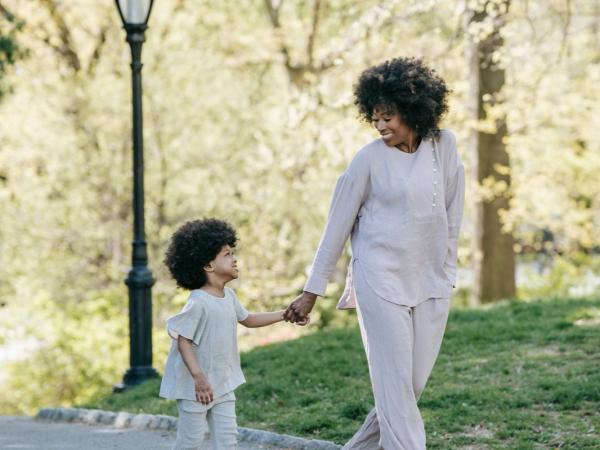 A mother and her young son stand together by a lamppost at dusk